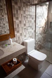 a bathroom with a toilet and a sink and a shower at Casa em Tiradentes 14 pessoas in Tiradentes