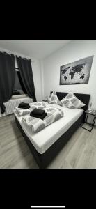 Un dormitorio con una gran cama blanca con almohadas. en Stylish & Relaxing Modernes Apartment mit Privatparkplatz, en Gelsenkirchen