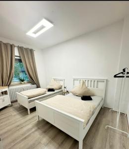 Un dormitorio blanco con dos camas y un sofá. en Stylish & Relaxing Modernes Apartment mit Privatparkplatz, en Gelsenkirchen