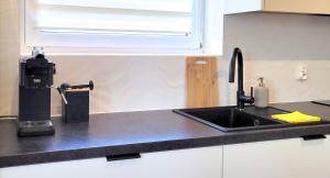 a kitchen counter with a sink and a window at Miriam Apartment Kraków Borkowska - Parking in Kraków +9 photos