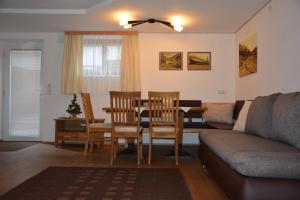 ein Wohnzimmer mit einem Tisch, Stühlen und einem Sofa in der Unterkunft Ferienwohnung Dolomitenheim in Außervillgraten