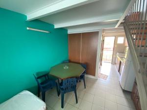 a room with a table and chairs and a staircase at JCM location in Les Trois-Îlets