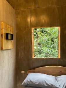 ein kleines Zimmer mit einem Fenster und einem Bett darin in der Unterkunft EB5 Escape-Contemporary Stay, San Marcos La Laguna, City Art in San Marcos La Laguna