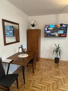 a dining room with a table and a tv on the wall at Noclegi Rybacka in Jarosław