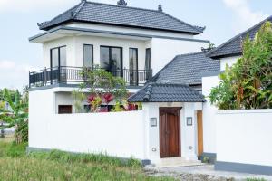 una casa blanca con techo negro en Entire villa Luxury Peaceful Pool Views Ubud, en Ubud