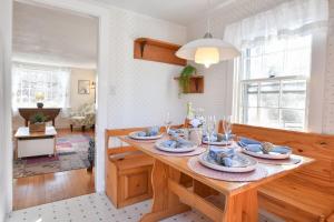 a kitchen with a table with plates of food on it at 15556 - Walk to Skaket Beach or Bike to Rail Trail w Outdoor Shower SUP Board Ping Pong Table in Orleans +23 photos