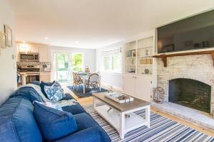 Una sala de estar con un sofá azul y una chimenea. en Beautiful Home Easy Access to Beaches, en Brewster