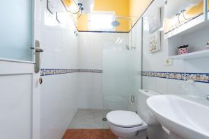 a white bathroom with a toilet and a sink at Balcony Spacious 2BR Arucas Historic Center in Arucas +27 photos