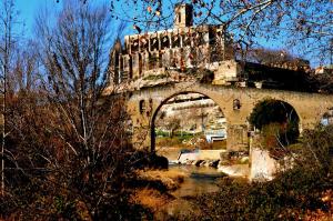 an old stone bridge with an arch over a river at Apartments San Ignacio de Loyola in Manresa