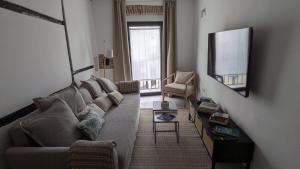 a living room with a couch and a television at Casa Carola in Trujillo