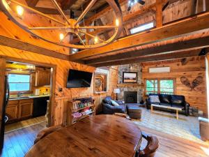 a living room with a wooden ceiling and a table at Private and Cozy Cabin Close to Williamsport, PA in Linden