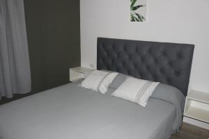 a bedroom with a large bed with a gray headboard at Cabañas Gadiel in San José de las Salinas +23 photos