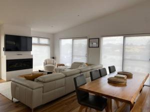 a living room with a couch and a table at Rusty's Ridge in Jindabyne