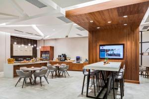 a restaurant with tables and chairs and a kitchen at North Charleston Marriott in Charleston