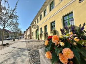 a bouquet of flowers in front of a yellow building at Apartments Herzberg in Kaxdorf