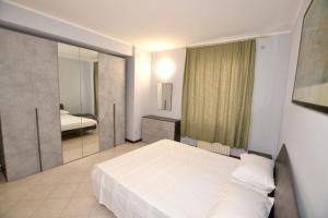 デセンツァーノ・デル・ガルダにあるAppartamento Capolaterraの大きな白いベッドと鏡のある寝室