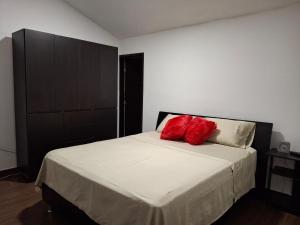 a bedroom with a bed with two red pillows on it at Apartamento en un 4to piso cerca al coliseo en Armenia in Armenia