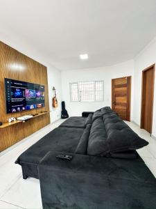 um quarto com uma cama grande e uma TV de tela plana em Hospedagem Congonhas 5 em São Paulo