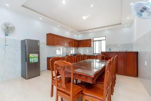 a kitchen with a table and chairs and a refrigerator at C2-53 Hoàng My Villa in Vung Tau