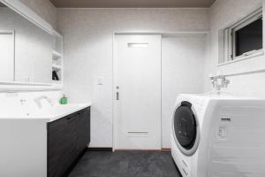 a bathroom with a washing machine and a sink at The Serenity in Nishi-nijō