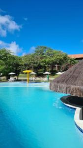 a swimming pool with a yellow umbrella and blue water at Flat Monte Castelo ,Vista Incrível,Conforto in Sairé