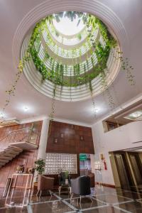 a lobby with a large ceiling with plants at Copas Executive Hotel in Cascavel