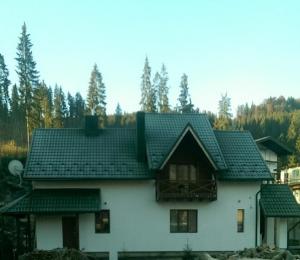 a white house with a black roof at Proskurov Holiday Home in Bukovel