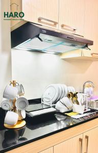 eine Küchentheke mit einem Haufen Geschirr darauf in der Unterkunft Condo near Session Road with Balcony in Baguio City