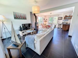 un salon avec un canapé blanc et une télévision dans l'établissement Maison calme, proche tennis, 3 chambres, terrasse, Wi-Fi, parking - FR-1-361-554, à Jullouville
