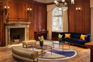 a living room with a blue couch and a fireplace at London Marriott Hotel County Hall in London