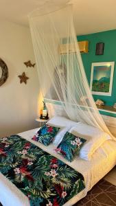 a bedroom with a bed with a mosquito net at Résidence Cocody in Sainte-Anne