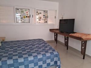 una camera con letto e TV su un tavolo di Smilesurf room a Rio de Janeiro Altre 13 foto