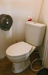 a white toilet in a bathroom with a toilet paper dispenser at WaterMellow Hostel in Koh Tao +20 photos