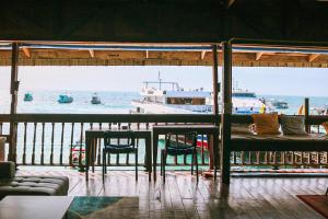 a table and chairs and a boat in the water at WaterMellow Hostel in Ko Tao