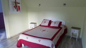 a bedroom with a large bed with red and white pillows at Hotel de la Gare in Mézidon-Canon