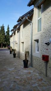 um edifício de tijolos com vasos de plantas ao lado em Hotel de la Gare em Mézidon-Canon