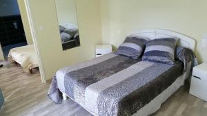 a bedroom with a bed with pillows and a mirror at Hotel de la Gare in Mézidon-Canon