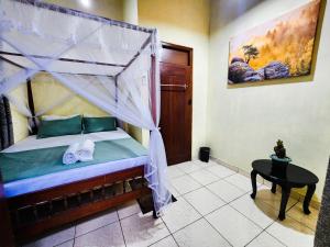 a bedroom with a bed with a canopy and a table at The Eagle in Galle
