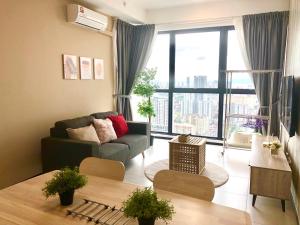 a living room with a couch and a large window at Urban Suite Condominium By Blue Sky Holidays in Jelutong