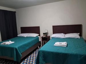 une chambre d'hôtel avec deux lits avec des serviettes dessus dans l'établissement Hotel Posada San Jose, à Malacatán 24 autres photos