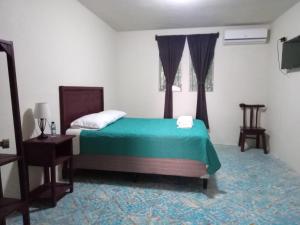 une chambre avec un lit, une table et une fenêtre dans l'établissement Hotel Posada San Jose, à Malacatán