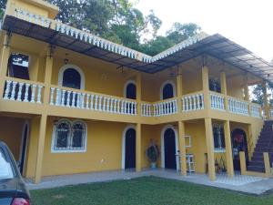 une maison jaune avec un balcon dans l'établissement Hotel Posada San Jose, à Malacatán