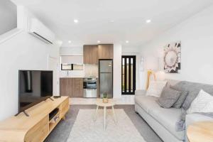 a living room with a couch and a table at Exceptional Value For Money Sunny Warm 5 Mins CBD in Christchurch