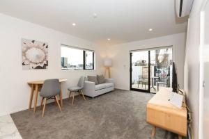 a living room with a couch and a table at Exceptional Value For Money Sunny Warm 5 Mins CBD in Christchurch +17 photos