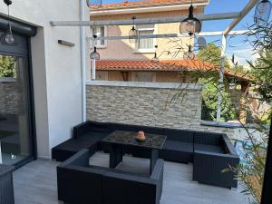 a patio with a table and chairs in front of a building at Villa lyon 8e, 8 personnes Piscine jardin, parking privé, terrain de pétanque in Monplaisir