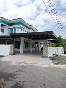 a large white house with a parking lot at KJ Homestay, BINTULU in Bintulu