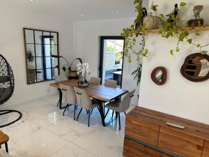 a dining room with a wooden table and chairs at Villa lyon 8e, 8 personnes Piscine jardin, parking privé, terrain de pétanque in Monplaisir