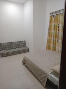 a bedroom with a bed and a couch at KJ Homestay, BINTULU in Bintulu