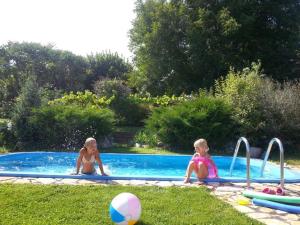 Dos chicas están sentadas en una piscina en Aranyos Ég en Ibafa