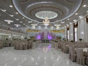 a banquet hall with tables and chairs and a chandelier at Qibla Tozabog in Khiva +120 photos